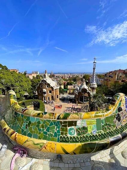 The colorful mosaic bench at Park Guell with houses in the background