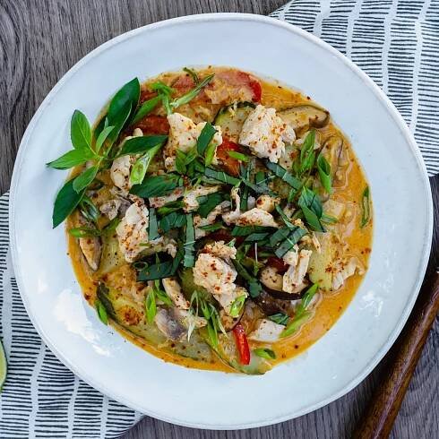 whitefish curry with basil in white bowl.
