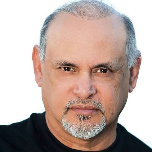 A bald man with a beard is wearing a black shirt