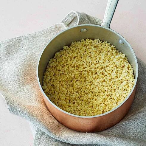 cooked millet in a copper pan