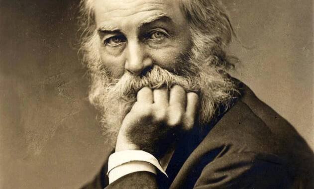 Sepia photograph of an elderly man with a long beard and moustache, resting his chin on his hand, looking thoughtfully at the camera.