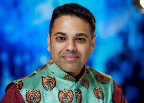 Professional photo of someone in a mint green traditional Indian outfit with pattern.