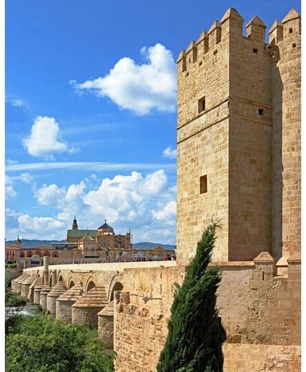 Sunny day in Cordoba may with a crowd walking over the Puente romano between the Mesquita and the Torre de la Calahorra