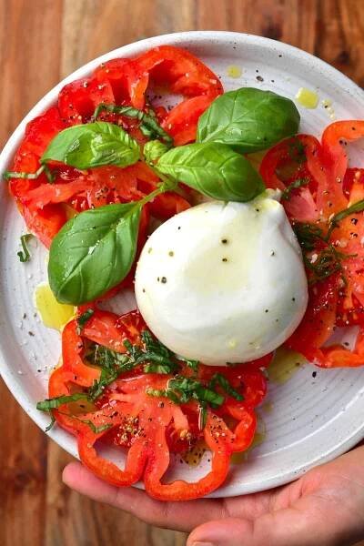 Sliced tomatoes and burrata cheese on a plate