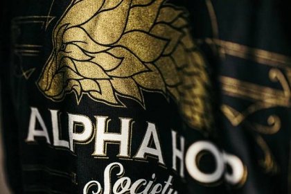 Close up of Alpha Hop Society T-shirt with black, white, and shimmering gold