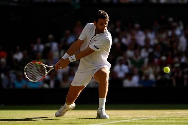 Cameron Norrie playing tennis at Wimbledon.