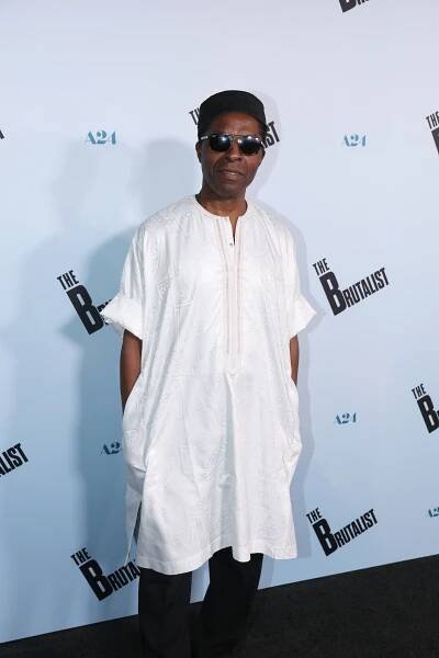 Isaach de Bankolé poses in a white shirt and black sunglasses.