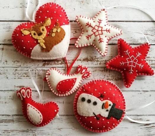 some ornaments are hanging on a white wooden table with snowflakes and other decorations