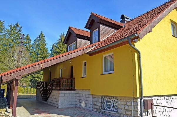 a yellow house with a red roof at Penzion Pod Boubínem in Kubova Huť