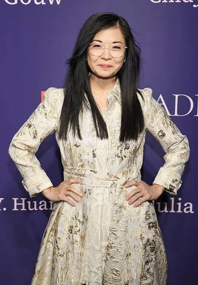 closeup of her wearing a dress with longer hair and glasses