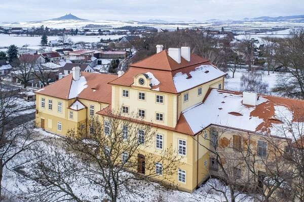 Pohled na zámek od jihovýchodu, v pozadí hrad Hazmburk