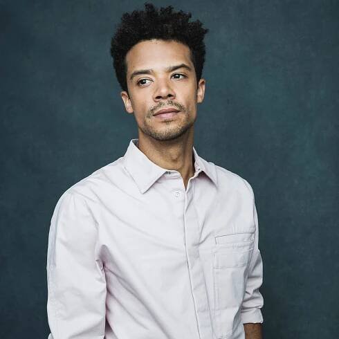 Image may contain Jacob Anderson Clothing Shirt Head Person Face Photography Portrait Happy Smile and Adult
