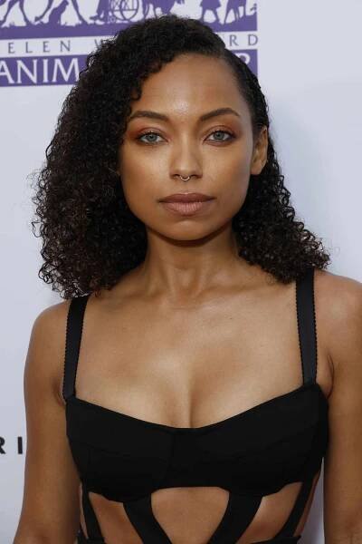 Logan Browning with a curly medium length haircut with side part