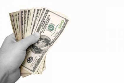 Hrst peněz izolovaných na bílém pozadí. peníze má selektivní barva, a ruka je v černé a bílé. — Stock obrázek
