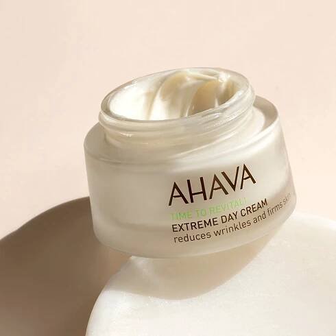 Open jar of AHAVA Extreme Day Cream on a neutral background.