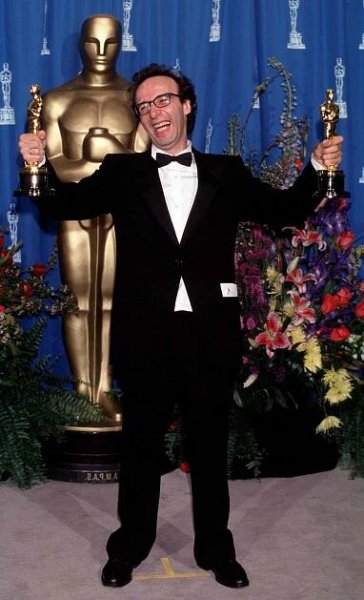 Roberto Benigni poses with two Oscars, including a trophy for Best Actor for 'Life Is Beautiful,' in the press room at the 71st annual Academy Awards in L.A. on March 21, 1999