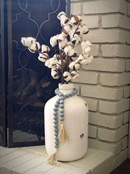 a white vase filled with flowers on top of a window sill next to a brick wall