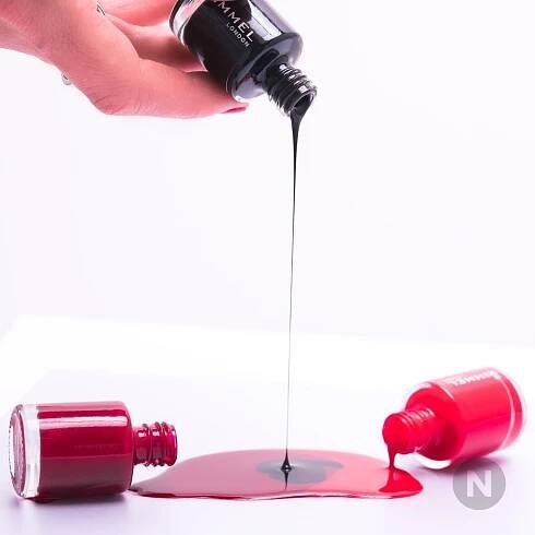 someone is pouring red liquid onto an apple