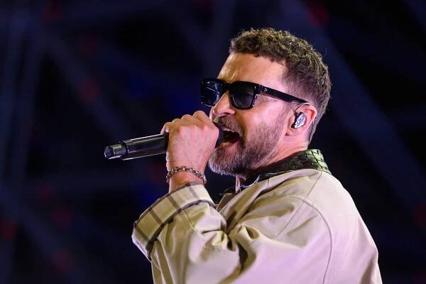 Justin Timberlake singt bei Iconica Festival 2025 in Sevilla auf der Bühne, trägt Sonnenbrille und Mikrofon in der Hand.