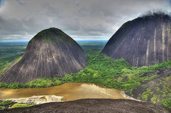 View from above on two round hills and a brown river 