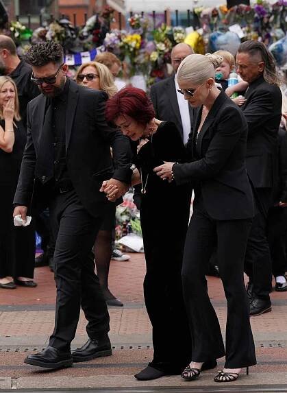 The family of Ozzy Osbourne (left to right) Jack, Sharon and Kelly Osbourne, view the messages and floral tributes left at the Black Sabbath Bridge bench on Broad Street in Birmingham in memory of Black Sabbath frontman Ozzy Osbourne