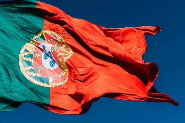 Portugalská vlajka izolovaná na modré obloze vlnící se ve větru. — Stock obrázek