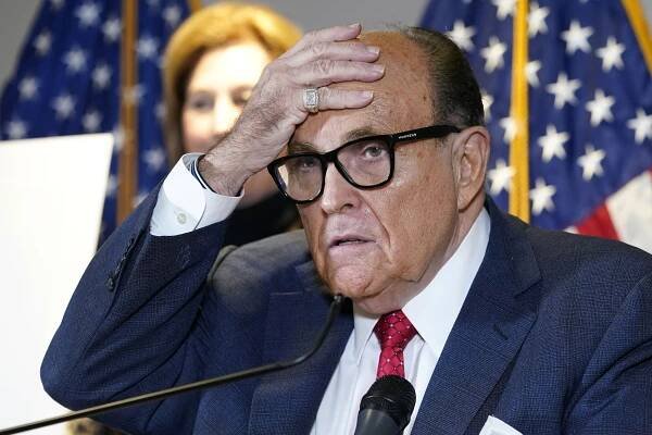 Rudy Giuliani has his hand on his head.