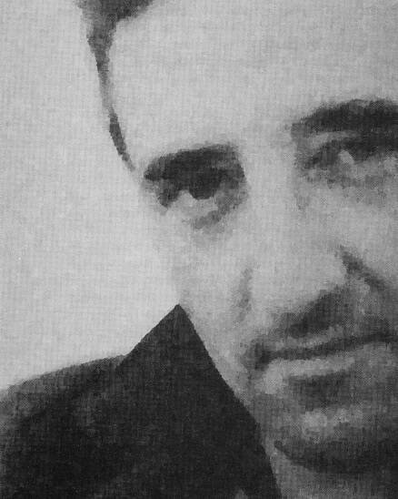 Grainy black and white photograph portrait of Roberto Bolaño, a man with deep set eyes and thick eyebrows, wearing a black jacket with a popped collar.