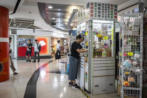 Woman at a stall selling incense and essential oils in Hong Kong.