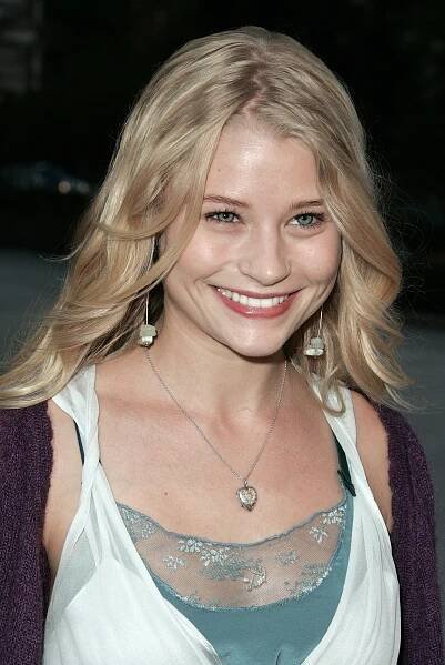 a woman with long blonde hair smiling at the camera