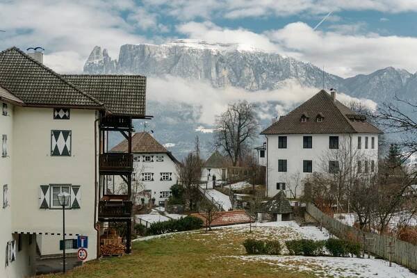 bezplatná Malebná vesnička Corvara v Badii se zasněženými Alpami v pozadí. Základová fotografie