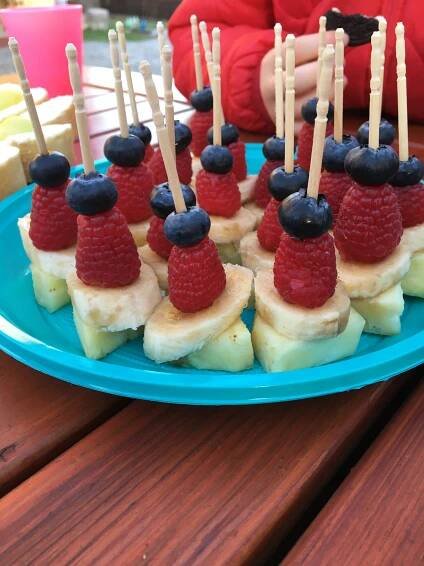 a blue plate topped with bananas and raspberries on top of banana wedges