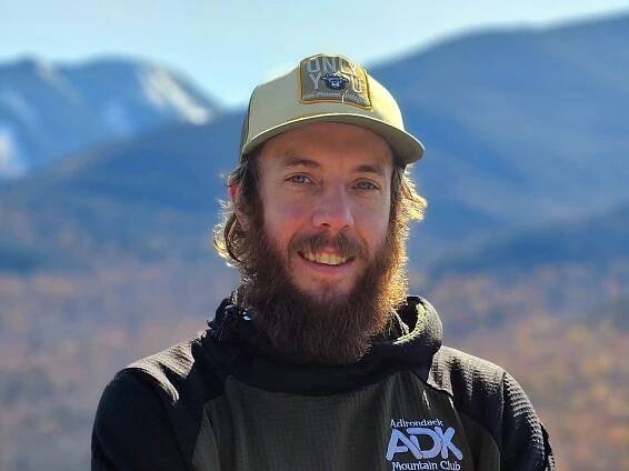 Photo of a man with a beard on a mountain