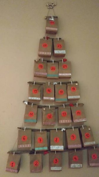 a christmas tree made out of brown packages with numbers on them and tags attached to it