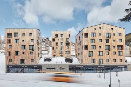Bytové domy Aparthotelu Svatý Vavřinec v centru Pece pod Sněžkou vyrůstají ze zelené střechy obchodů