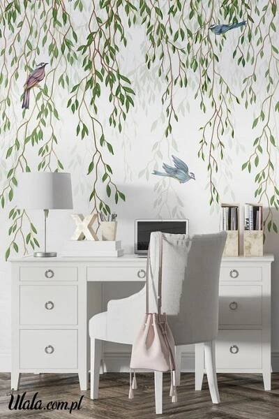 a white desk topped with a chair next to a wall covered in leaves and birds