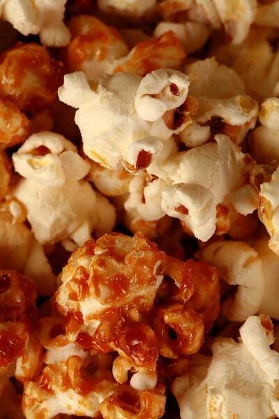 Close up photo of a bowl of two-tone popcorn: Maple White Cheddar Popcorn. Half of the popcorn is covered with maple caramel, the other half is white - white cheddar.