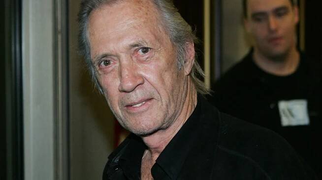 David Carradine in black jacket staring