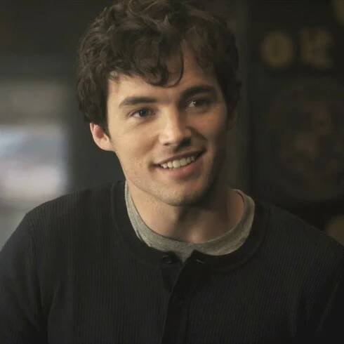 a young man smiling at the camera