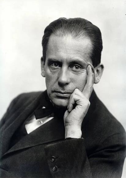an old photo of a man in a suit and tie with his hand on his chin