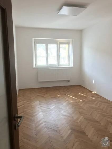 Nově vybílené zdi a parkety ve zrenovované místnosti. 