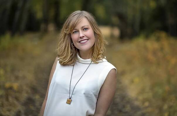 A young woman with blue eyes poses for a portrait on a beautiful fall day near Kamloops, British Columbia, Canada, Thompson Okanagan region