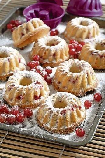 small pastries on a tray with berries and powdered sugar