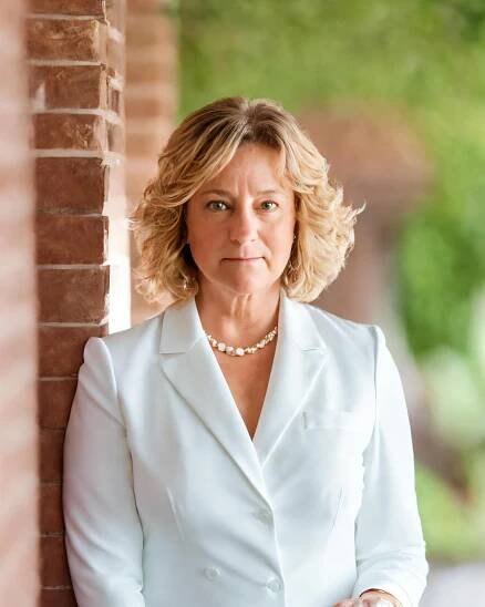 Sheila in White Suit against Brick Wall