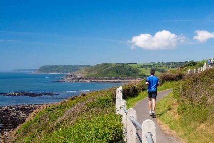 Image of a runner on the Coast Path near Langland BAy Swansea Gower Wales