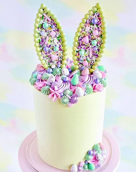 there is a cake decorated with candy and bunny ears on the top of this cake