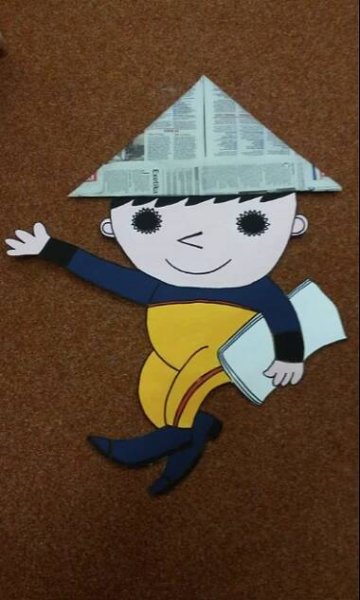 a paper cut out of a boy wearing a fireman's hat