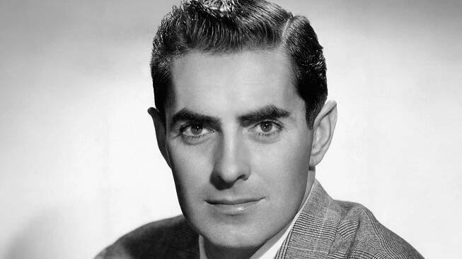 a man in a suit and tie posing for a photo