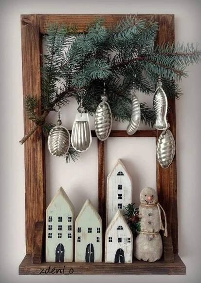 a wooden frame with ornaments hanging from it and a snowman on the ledge next to them