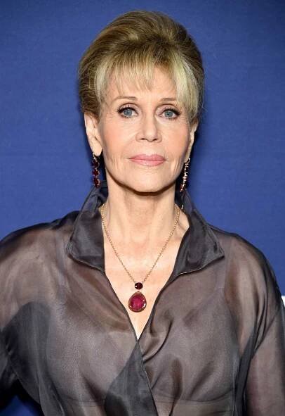 Jane Fonda with a volumized blonde updo with bangs and light pink makeup